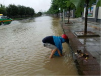 暴雨袭城 他们水中冒雨排涝 